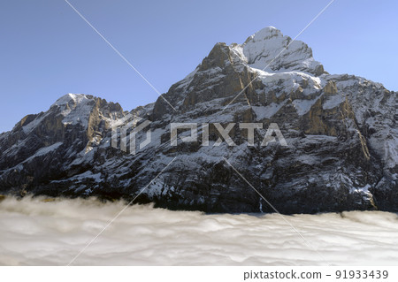 Mountains and clouds in the valley. Natural landscape high in the mountains. Grindewald, Switzerland. Mountains and clouds in the valley. Natural landscape high in the mountains. Grindewald, Switzerland. 91933439