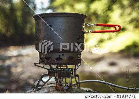 Cooking food using camping gas during the hike. 91934771