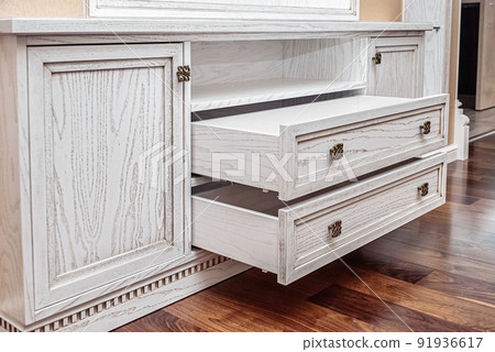 Built-in chest of drawers from veneer and solid ash in light enamel with gray patina. Detail of decorative wall in room. Modern furniture at home close view 91936617