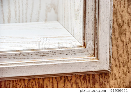 Fragment of built-in bookcase made of veneer and solid ash in light enamel with gray patina. Decorative wall at home. Furniture details closeup 91936631