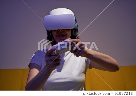 Woman with virtual reality headset and joystic is playing game. Woman with virtual reality headset and joystic is playing game. 91937218