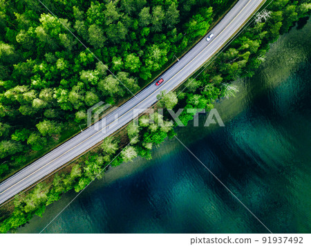 Aerial view of coastline road with green woods and blue lakes water in summer Finland. 91937492