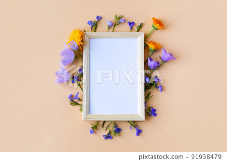 Blue bluebell, lobelia flowers and orange calendula flowers with a white text frame on an orange background. Summer flat lay Blue bluebell, lobelia flowers and orange calendula flowers with a white text frame on an orange background. Summer flat lay 91938479
