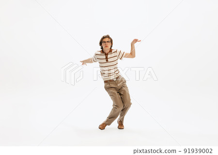 Portrait of expressive young man in vintage outfit dancing, posing isolated over white studio background 91939002