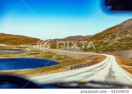 Driving a car on mountain road. Nature Norway. Polar circle. The way to Nordkapp Driving a car on mountain road. Nature Norway. Polar circle. The way to Nordkapp 91939659