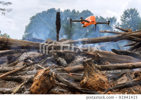 A drone is being used by the fire services to follow the fire into the forest trees 91941415