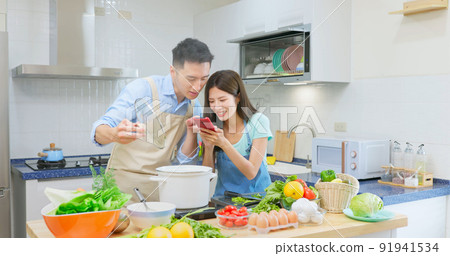 young couple are cooking together young couple are cooking together 91941534