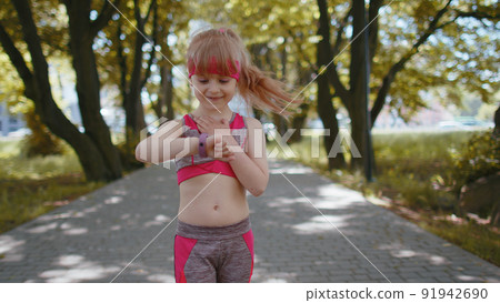 Athletic runner girl look at smart watch clock device fitness bracelet checking time, heart rate 91942690