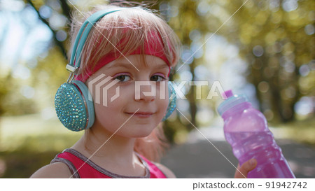 Athletic fitness sport jogger toddler kid girl drinking water from bottle after training exercising Athletic fitness sport jogger toddler kid girl drinking water from bottle after training exercising 91942742
