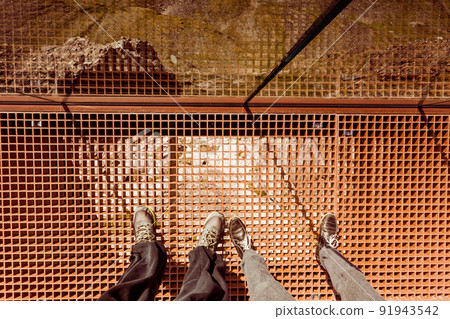 Tourist feet on Dalsnibba platform floor, Norway 91943542