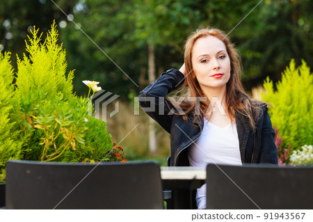 Woman waiting in outdoor restaurant cafe. 91943567