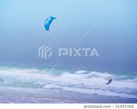 Kite surfer riding waves. Kiteboarding sport. Kite surfer riding waves. Kiteboarding sport. 91943568