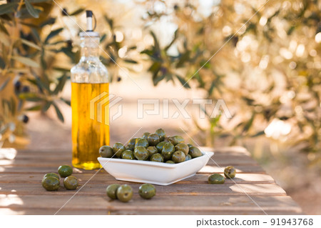 green olives and oil on table in olive grove green olives and oil on table in olive grove 91943768