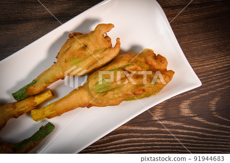 Stuffed zucchini flower on plate. 91944683