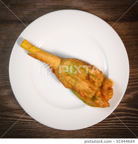 Stuffed zucchini flower on plate. 91944684