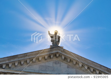 Statue of Jesus Christ surrounded by sun rays against clear blue sky 91945005