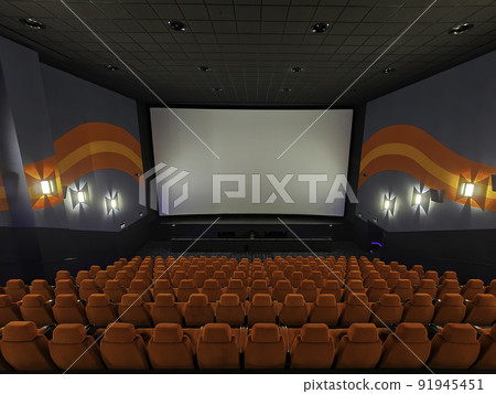 Inside of the big cinema. Empty seats waiting the movie on the white screen. Your text or picture on the white screen. 91945451