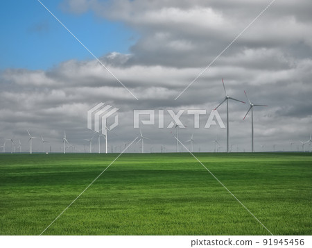 Eolian farm renewable energy in fresh green field against clear blue sky Eolian farm renewable energy in fresh green field against clear blue sky 91945456