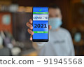 Covid-19 Health Passport. Vaccinated man holding cell phone with covid 19 vaccination proof 91945568