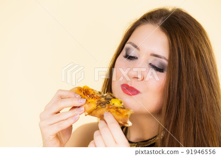 Woman eating hot pizza slice 91946556