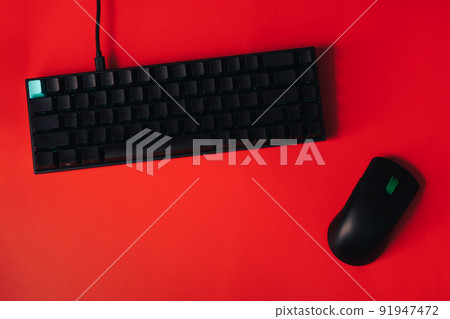 Computer gaming mouse and keyboard against red background 91947472