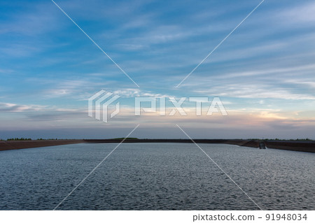 Upper water reservoir of the pumped storage hydro power plant Dlouhe Strane in Jeseniky Mountains, Czech Republic.. During summer evening, sunset with blue sky and clouds. Upper water reservoir of the pumped storage hydro power plant Dlouhe Strane in Jeseniky Mountains, Czech Republic.. During summer evening, sunset with blue sky and clouds. 91948034