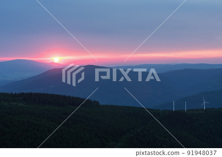 Wind turbines in Bear mountain , view from upper water reservoir of the pumped storage hydro power plant Dlouhe Strane in Jeseniky Mountains, Czech Republic. Summer sunset. Wind turbines in Bear mountain , view from upper water reservoir of the pumped storage hydro power plant Dlouhe Strane in Jeseniky Mountains, Czech Republic. Summer sunset. 91948037