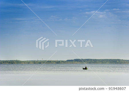 a lonely fisherman on the boat in the middle of the Svitiaz lake, Shatsk National Natural Park, Ukraine 91948607