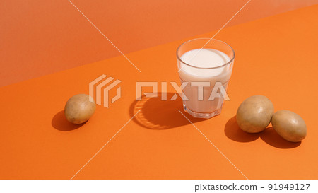 A glass of potato milk on the table with potatoes 91949127