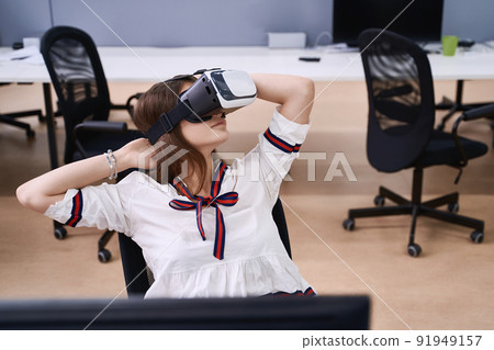 Female professional using vr virtual reality headset at desk in office 91949157