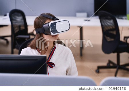 Female professional using vr virtual reality headset at desk in office 91949158