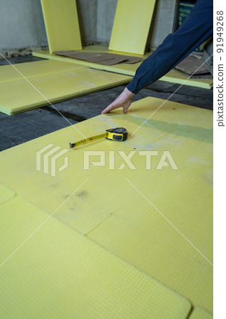 Installation of expanded polystyrene in the room for floor insulation, repair work alone, yellow expanded polystyrene. Installation of expanded polystyrene in the room for floor insulation, repair work alone, yellow expanded polystyrene. 91949268