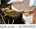 Hong Kong charcoal Waffle is baked on waffle iron machine. 91949369