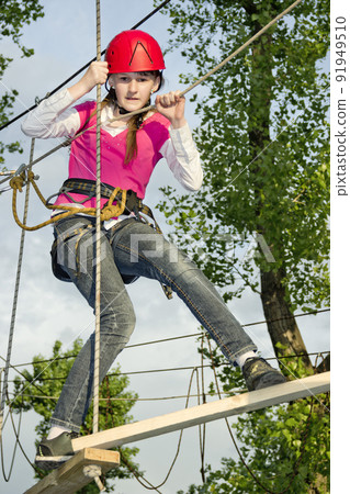 a teenage girl goes on hinged trail in extreme rope park 91949510