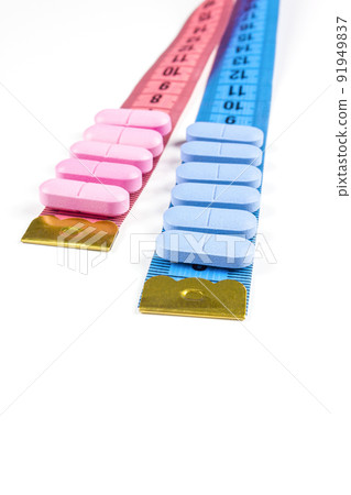 Pills with pink and blue measuring tape on white background. Concept of losing weight, diet, fat burning, healthy eating. Pills with pink and blue measuring tape on white background. Concept of losing weight, diet, fat burning, healthy eating. 91949837