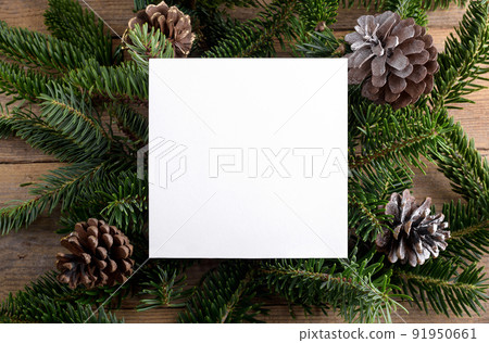 Christmas 5x5 card mockup template on natural fir twigs on wooden background. Design element for Christma Christmas 5x5 card mockup template on natural fir twigs on wooden background. Design element for Christma 91950661