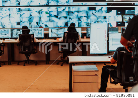 Male security operator working in a data system control room offices Technical Operator Working at workstation with multiple displays, security guard working on multiple monitors Male computer opera 91950891