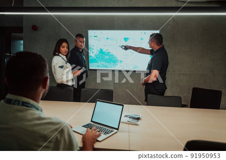 Group of Security data center operators working in a CCTV monitoring room looking on multiple monitors Officers Monitoring Multiple Screens for Suspicious Activities Team working on the System Contr 91950953