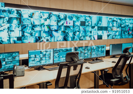 Empty interior of big modern security system control room, workstation with multiple displays, monitoring room with at security data center Empty office, desk, and chairs at a main CCTV security data 91951053