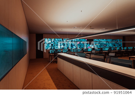 Empty interior of big modern security system control room, workstation with multiple displays, monitoring room with at security data center Empty office, desk, and chairs at a main CCTV security data 91951064