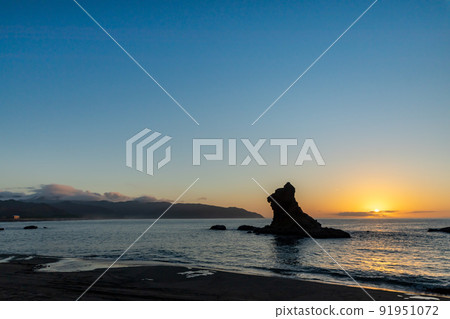 A lion rock towering on the Nichinan coast of Umegaoka beach in the color of the magic hour of the Pacific Ocean Hyuga Nada 91951072
