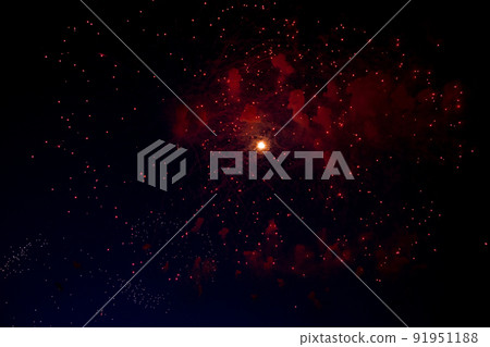 A bright flash in the center from the fireworks beginning to bloom and red sparks around against the background of the night sky. High quality photo A bright flash in the center from the fireworks beginning to bloom and red sparks around against the background of the night sky. High quality photo 91951188