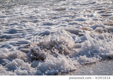 Splashes of water and foam against the sea on a sunny summer day 91951618