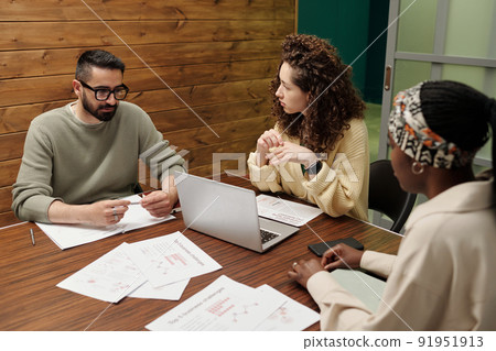 Group of young interracial coworkers brainstorming during discussion Group of young interracial coworkers brainstorming during discussion 91951913
