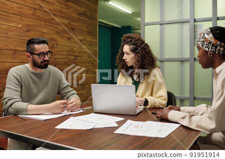 Three young intercultural employees working over new business project 91951914