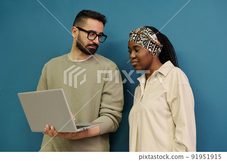 Two young employees looking for online information and discussing it Two young employees looking for online information and discussing it 91951915