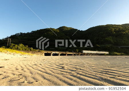 Kiha 40 on the Nichinan Line running on the Kumagaya River Bridge at the beach of Sannohama, Nichinan City, Miyazaki Prefecture 91952504