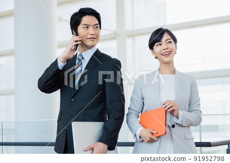 一個男人用智能手機說話,一個女人用筆記本微笑 一個男人用智能手機說話,一個女人用筆記本微笑 91952798