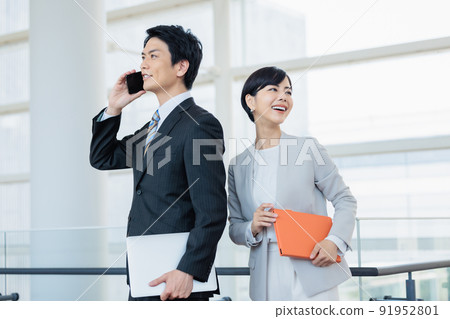 一個男人用智能手機說話,一個女人用筆記本微笑 一個男人用智能手機說話,一個女人用筆記本微笑 91952801