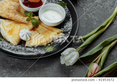 Pancakes with strawberries and creme black plate Pancakes with strawberries and creme black plate 91953072